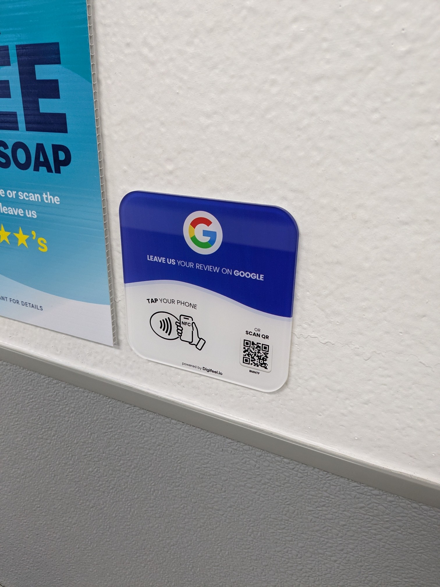 a tile on the wall that instructs you to scan the QR code or NFC tag to leave a Google review